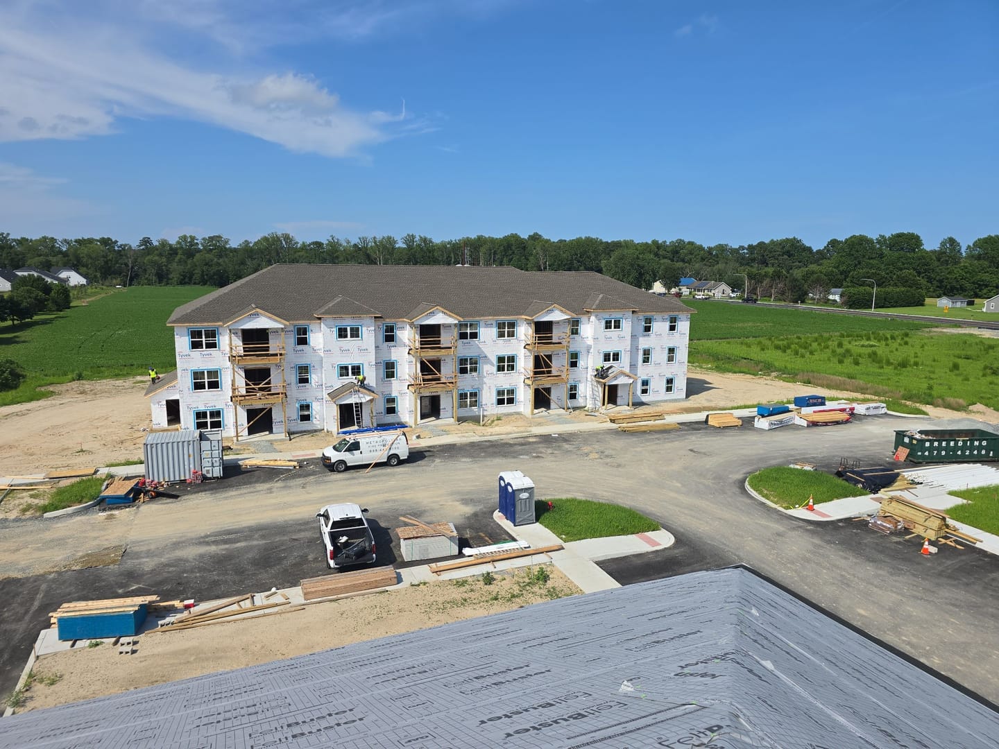 New three-story apartment building at Chapel Branch, seen from a freshly shingled roof