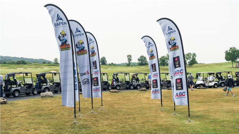 Eapen Open flags lined up beside the golf carts on the course