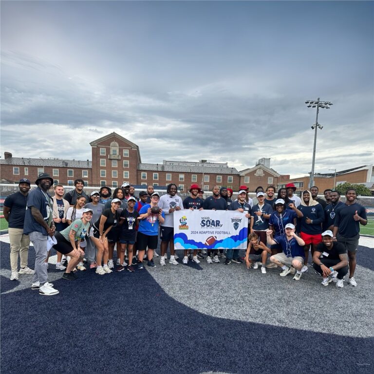 A big group with the So Kids Soar banner on the field