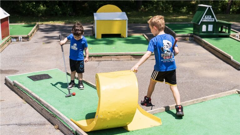 Kids in Panda shirts playing mini golf