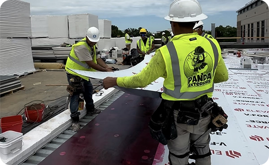A Panda Exteriors crew laying out a commercial roof